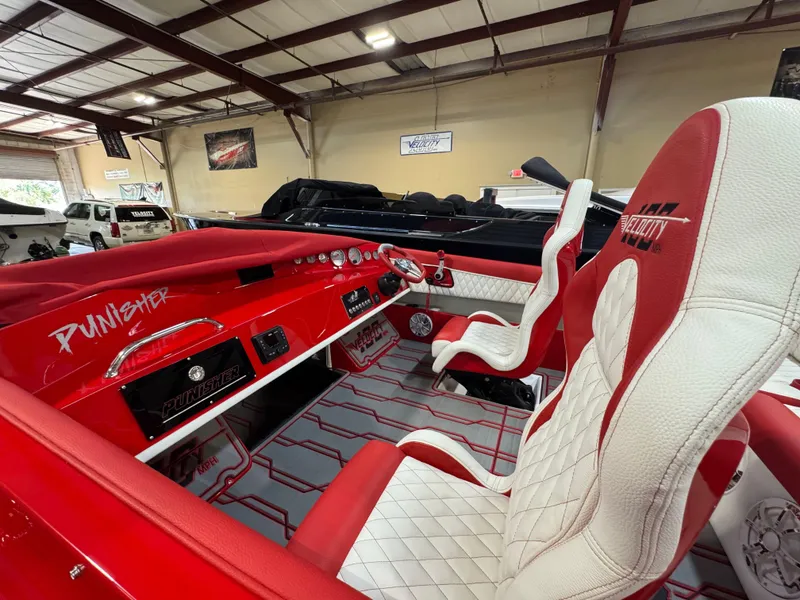Slide: The Image of Interior of 2026 Velocity 22 Punisher boat with red and white seating and dashboard. - 9
