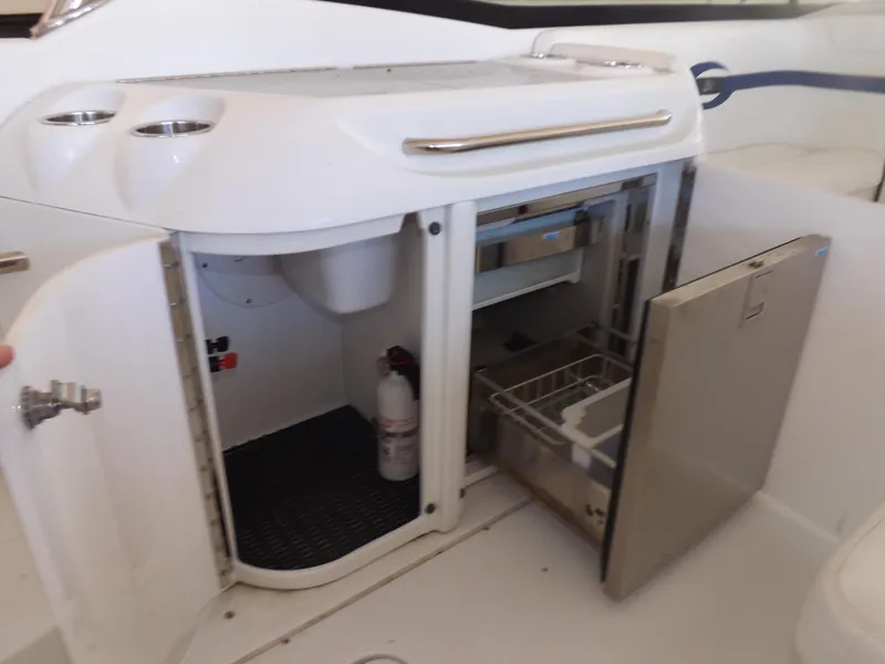 Slide: The Image of 2008 Formula 310 Bowrider boat interior with open storage compartments and mini fridge. - 12