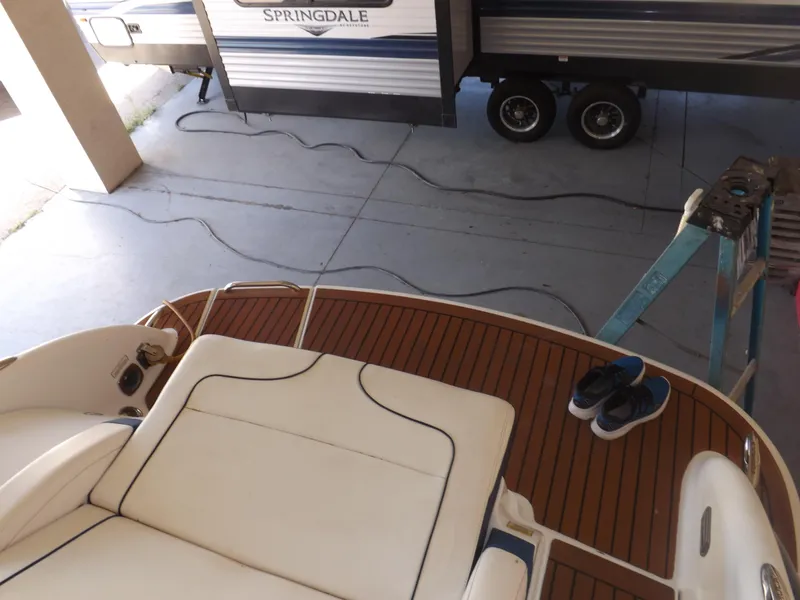 Slide: The Image of 2008 Formula 310 Bowrider boat with teak deck and white seating, parked near a Springdale trailer. - 30