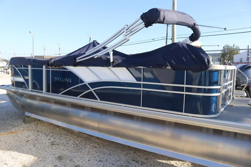 Slide: The Image of 2023 Sylvan L3 ENT pontoon boat with blue cover and sleek design. - 0