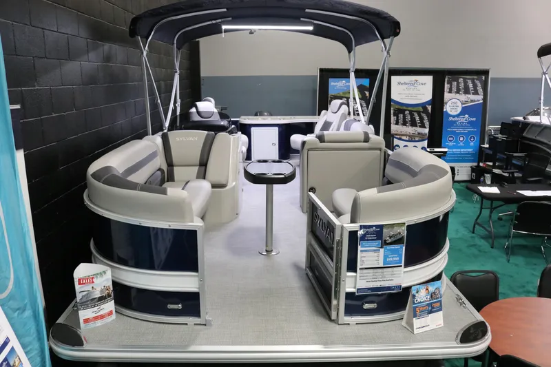 Slide: The Image of 2023 Sylvan L3 ENT pontoon boat on display indoors, featuring spacious seating and modern design. - 13