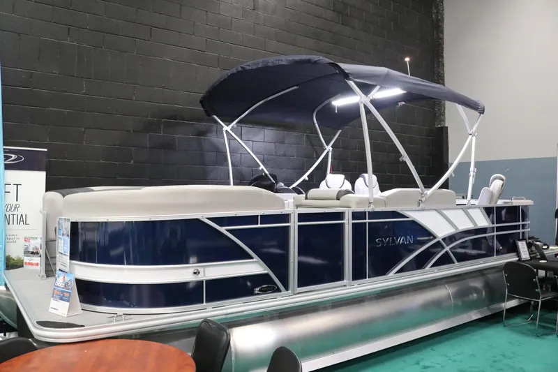Slide: The Image of 2023 Sylvan L3 ENT pontoon boat with canopy displayed indoors. - 2