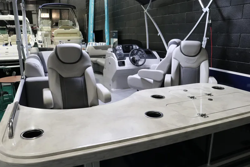 Slide: The Image of 2023 Sylvan L3 ENT boat interior with plush seating and modern dashboard. - 23