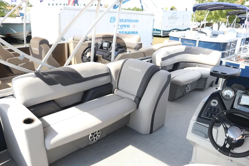 Slide: The Image of 2023 Sylvan L3 ENT pontoon boat interior with plush seating and modern dashboard. - 6
