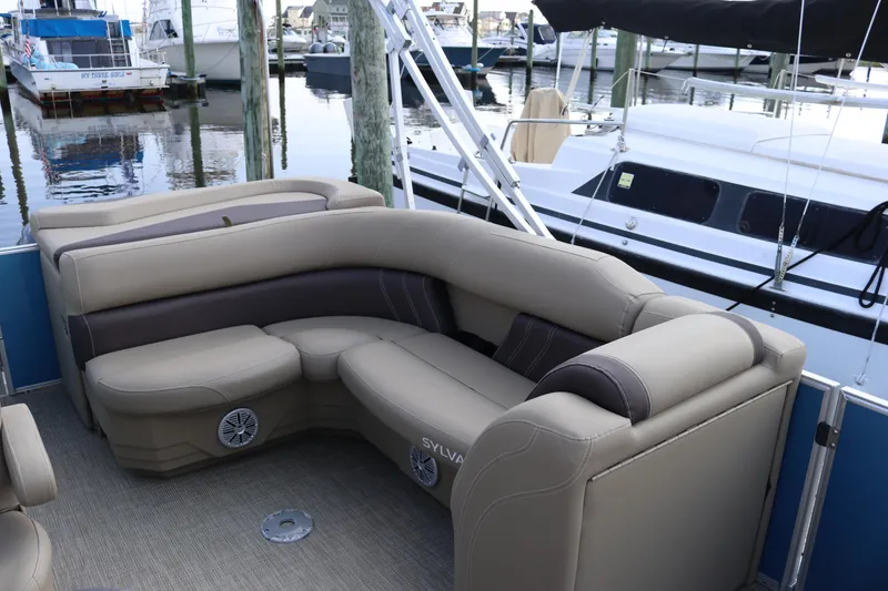 Slide: The Image of 2023 Sylvan Mirage 8520 Cruise pontoon boat with beige seating at a marina. - 11