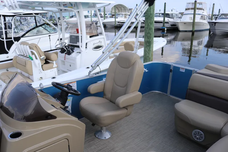 Slide: The Image of 2023 Sylvan Mirage 8520 Cruise pontoon boat interior at marina, featuring comfortable seating. - 12