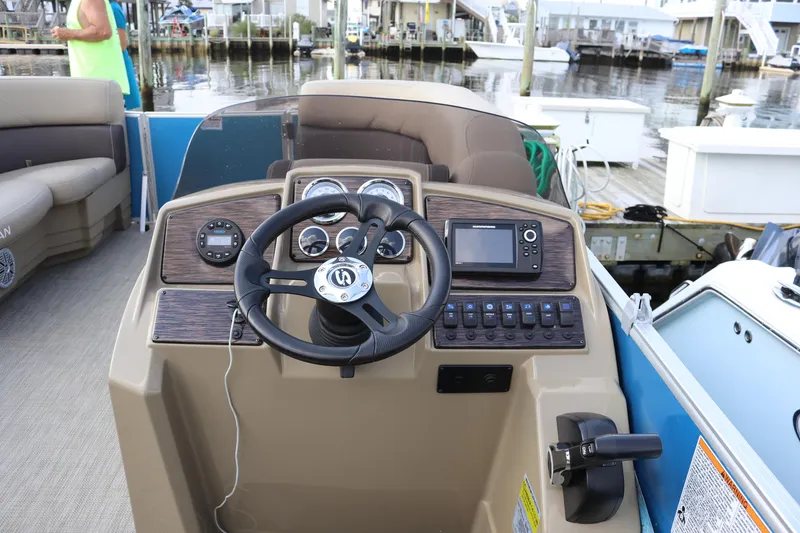 Slide: The Image of 2023 Sylvan Mirage 8520 Cruise boat dashboard with steering wheel and controls at marina. - 13