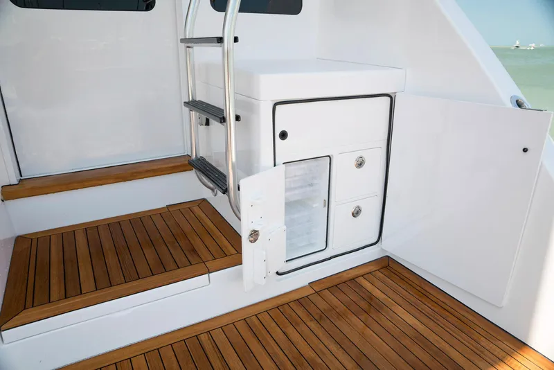 Slide: The Image of 2023 Bertram 61 Convertible yacht interior with wooden flooring and storage compartments. - 20