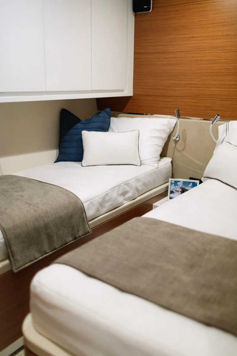 Slide: The Image of 2023 Bertram 61 Convertible cabin with twin beds and modern decor. - 28