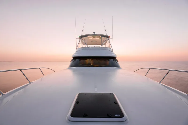 Slide: The Image of 2023 Bertram 61 Convertible yacht at sunset on calm waters. - 9