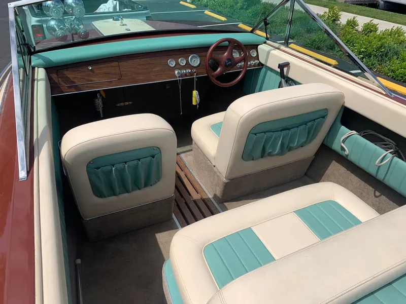 Slide: The Image of 2005 Coronado Custom boat interior with green and beige seats, wooden dashboard, and steering wheel. - 11