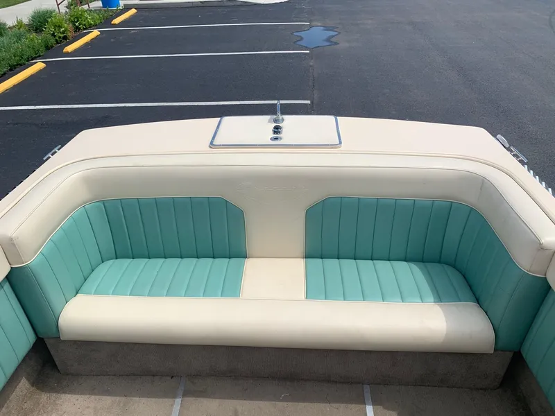 Slide: The Image of 2005 Coronado Custom boat with teal and cream seating in a parking lot. - 9
