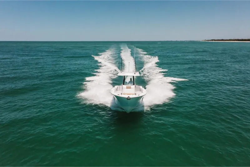 Slide: The Image of 2023 Bertram 28CC boat cruising on open water. - 19
