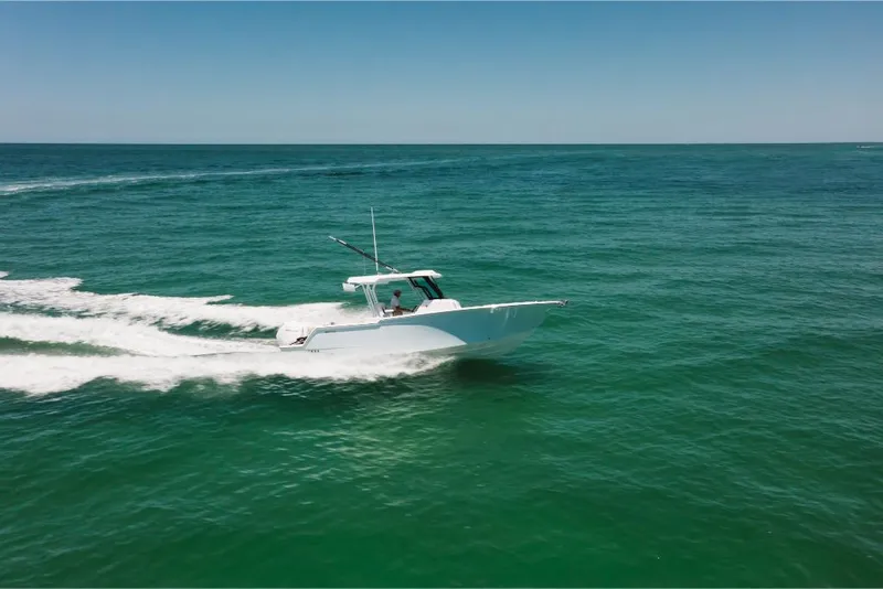 Slide: The Image of 2023 Bertram 28CC boat cruising on open water. - 23