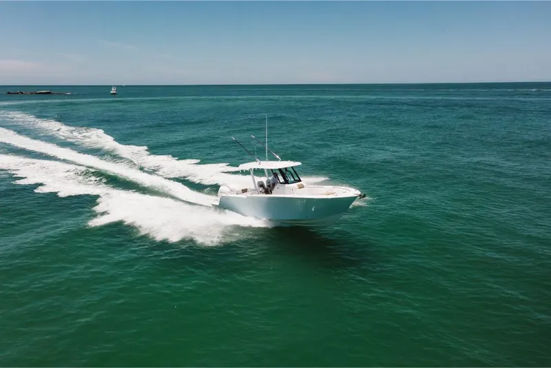 Slide: The Image of 2023 Bertram 28CC cruising on open water. - 25