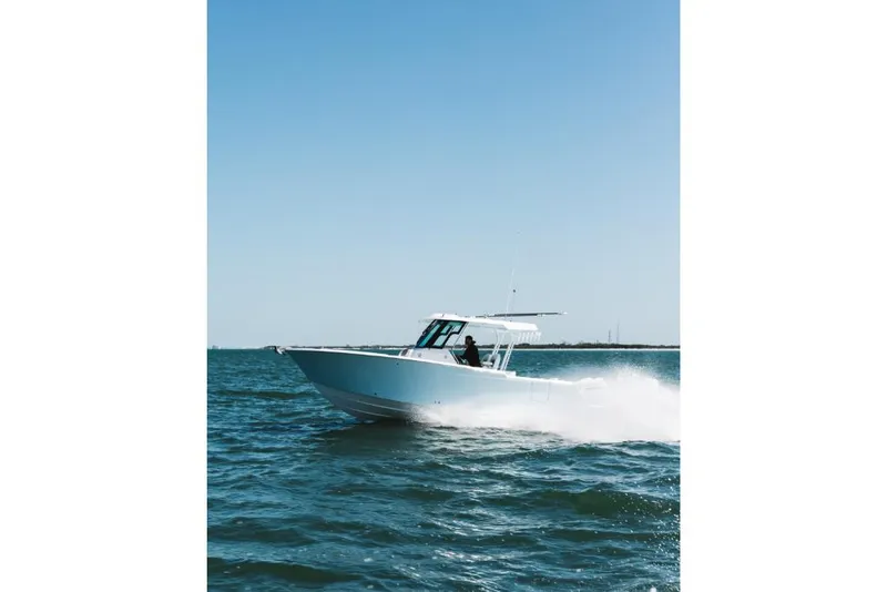 Slide: The Image of 2023 Bertram 28CC boat cruising on open water. - 32