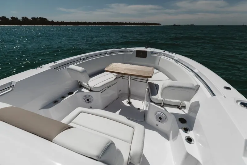 Slide: The Image of 2023 Bertram 28CC boat interior with seating and table on the water. - 34