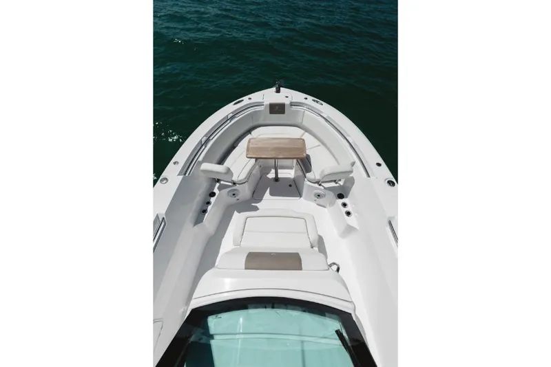 Slide: The Image of 2023 Bertram 28CC boat interior with seating and table on water. - 35