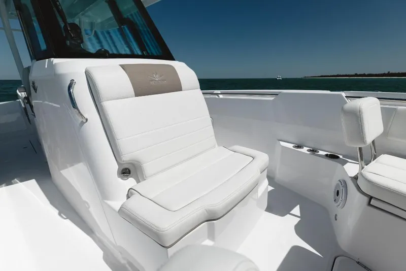 Slide: The Image of 2023 Bertram 28CC boat with white cushioned seating and ocean backdrop. - 38