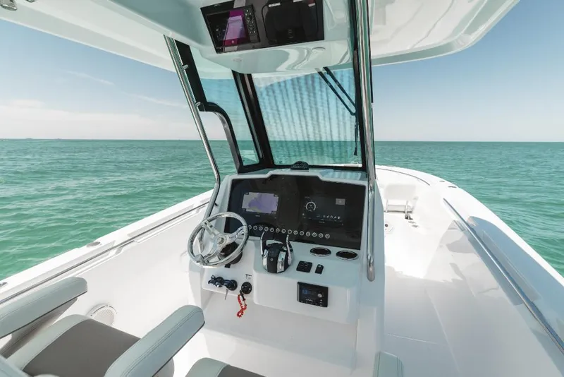 Slide: The Image of 2023 Bertram 28CC boat cockpit with modern controls and ocean view. - 49
