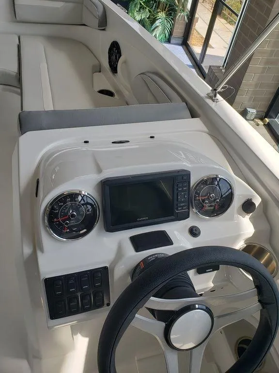 Slide: The Image of 2022 Hurricane SunDeck Sport 205 OB boat dashboard with steering wheel and control panel. - 6