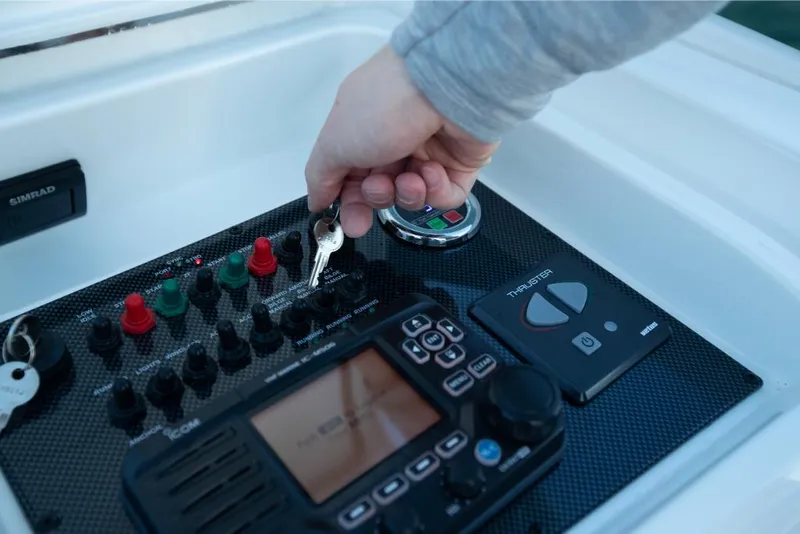 Slide: The Image of Hand starting the control panel of a 2023 Bertram 35 Flybridge boat. - 13
