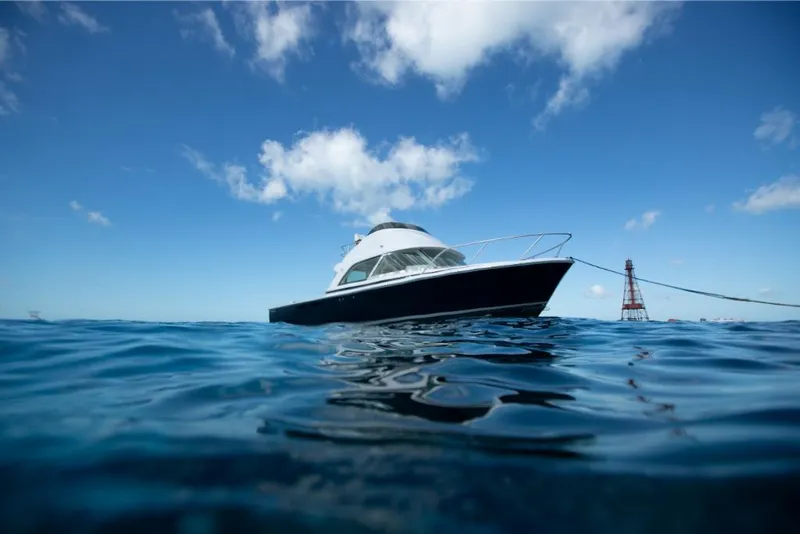 Slide: The Image of 2023 Bertram 35 Flybridge boat on open water under blue sky. - 19