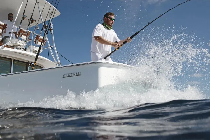 Slide: The Image of Man fishing on a 2023 Bertram 35 Flybridge boat in the ocean. - 34