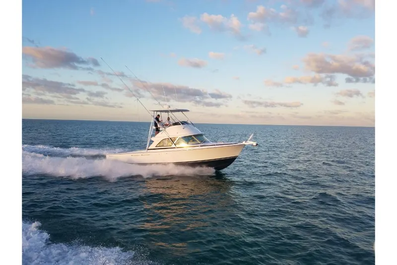Slide: The Image of 2023 Bertram 35 Flybridge cruising on open water at sunset. - 39
