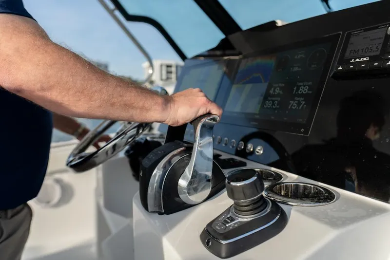 Slide: The Image of Man operating the controls of a 2023 Bertram 39CC boat. - 17