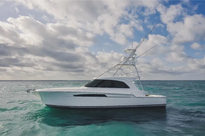 Slide: The Image of 2023 Bertram 50 Sport yacht on open water under cloudy sky. - 2