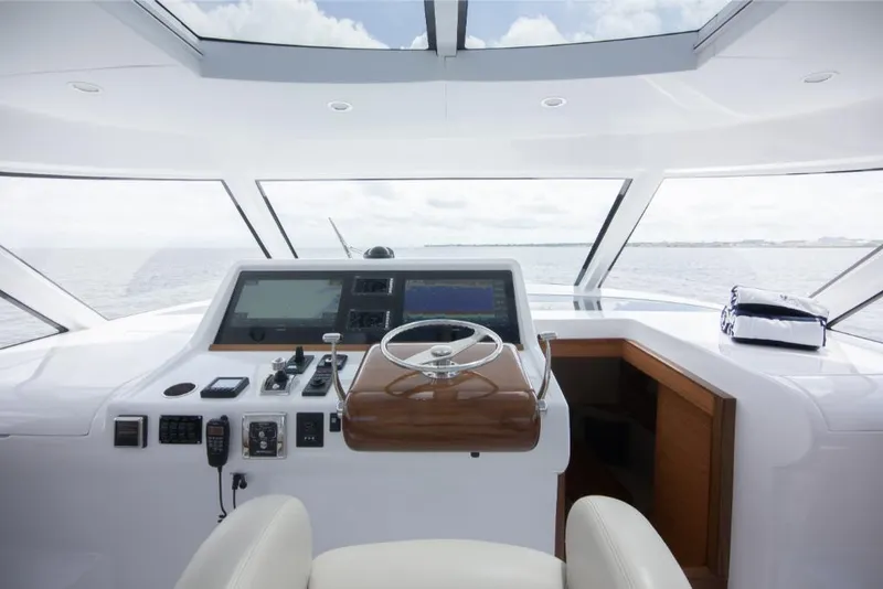 Slide: The Image of 2023 Bertram 50 Sport yacht helm with modern navigation equipment and panoramic ocean view. - 40