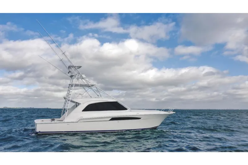 Slide: The Image of 2023 Bertram 50 Sport yacht on open water under cloudy sky. - 7