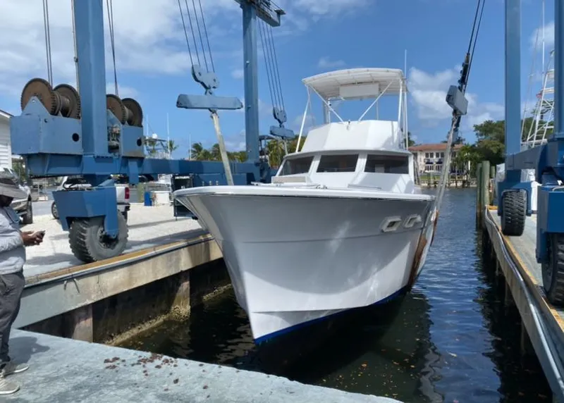The Image of 1971 Hatteras 45 Convertible boat being lifted at a marina. - 0