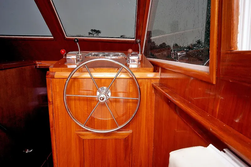 Slide: The Image of 1971 Hatteras 45 Convertible boat helm with wooden finish and steering wheel. - 15