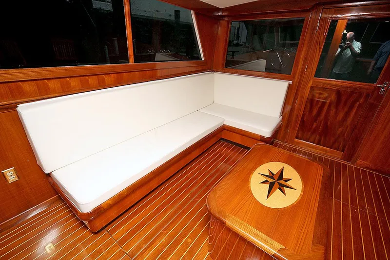Slide: The Image of 1971 Hatteras 45 Convertible yacht interior with white cushioned seating and wooden table. - 16