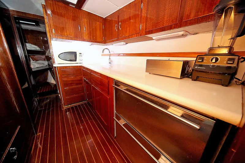 Slide: The Image of 1971 Hatteras 45 Convertible yacht kitchen with wooden cabinets and modern appliances. - 17