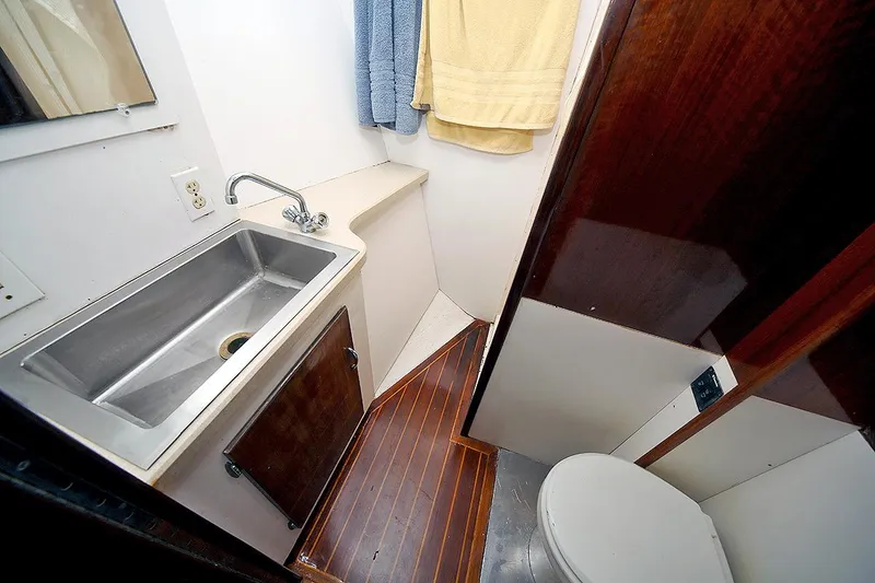 Slide: The Image of 1971 Hatteras 45 Convertible bathroom with stainless steel sink and wooden cabinetry. - 27
