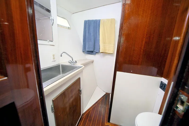 Slide: The Image of 1971 Hatteras 45 Convertible yacht bathroom with sink, towels, and wooden cabinetry. - 32