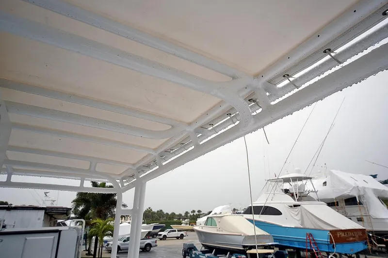 Slide: The Image of 1971 Hatteras 45 Convertible boat in a marina, view of the deck and surrounding boats. - 49