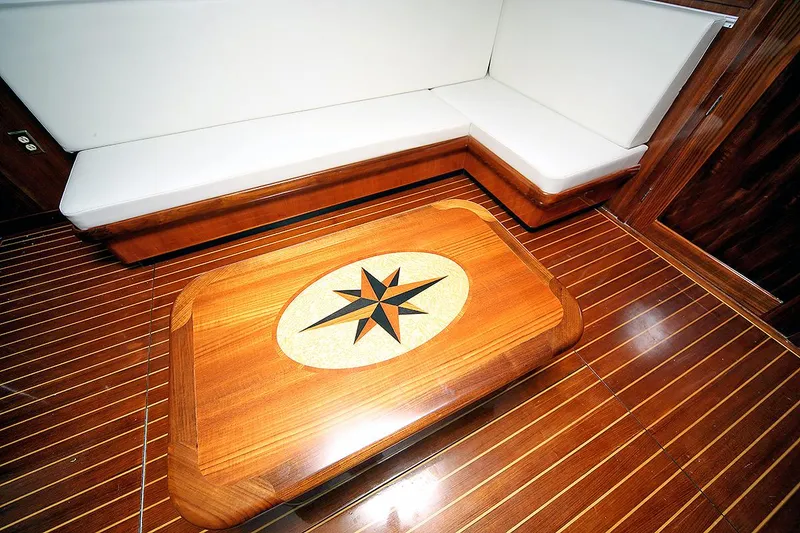 Slide: The Image of 1971 Hatteras 45 Convertible interior with compass rose table and white seating. - 9