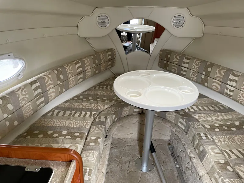 Slide: The Image of 2005 Rinker 250 Fiesta Vee cabin interior with patterned seating and round table. - 10