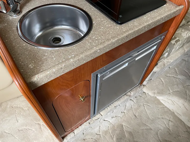 Slide: The Image of 2005 Rinker 250 Fiesta Vee boat interior with sink and mini fridge. - 14