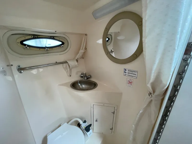 Slide: The Image of 2005 Rinker 250 Fiesta Vee boat bathroom with sink, toilet, and porthole window. - 19