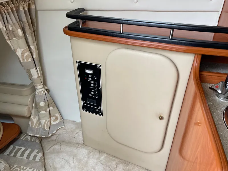 Slide: The Image of 2005 Rinker 250 Fiesta Vee cabin interior with control panel and beige upholstery. - 21