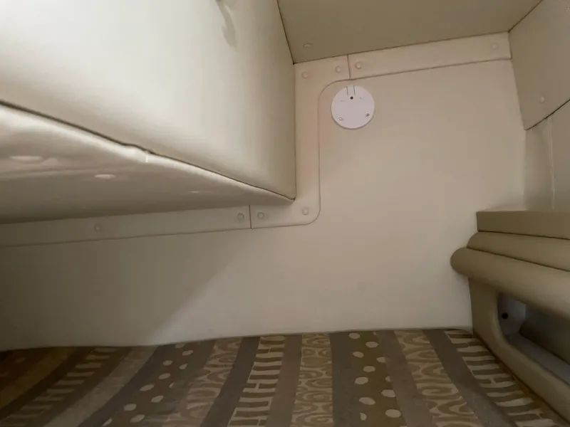 Slide: The Image of 2005 Rinker 250 Fiesta Vee cabin interior with beige upholstery and patterned flooring. - 23