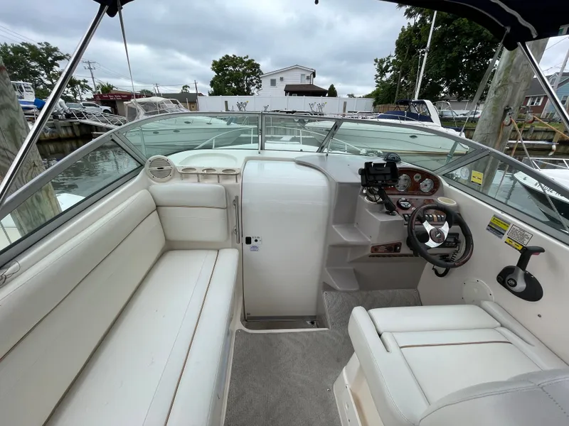 Slide: The Image of 2005 Rinker 250 Fiesta Vee boat interior with white seating and control panel. - 7