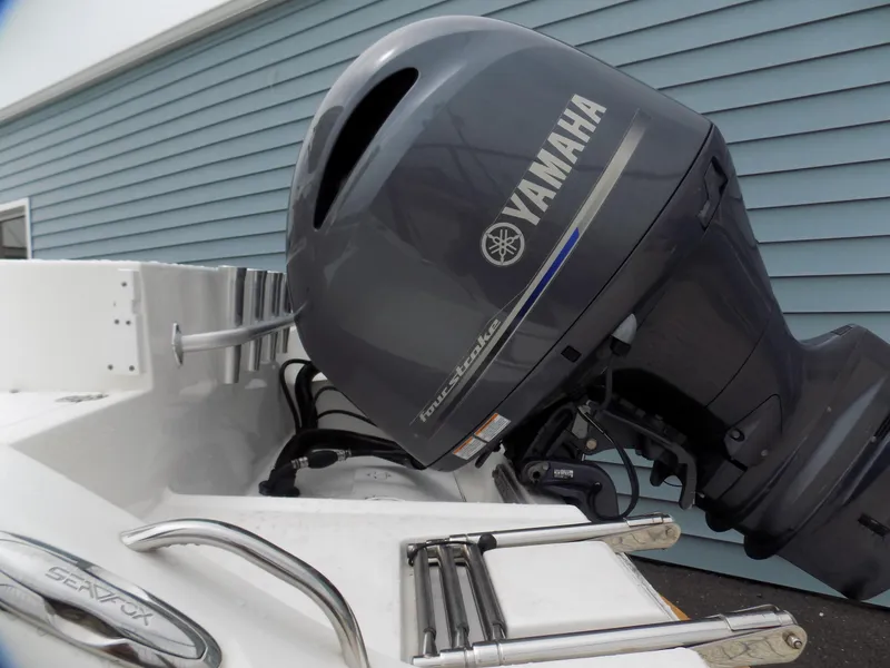Slide: The Image of 2017 Sea Fox 256 Voyager with Yamaha outboard motor, docked near blue siding. - 2