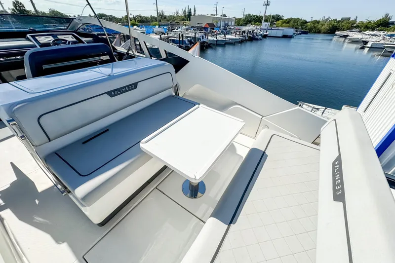 Slide: The Image of 2021 Fairline F Line 33 yacht interior with seating and table, docked at marina. - 12