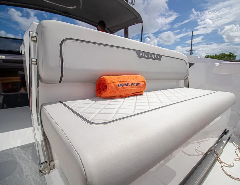Slide: The Image of 2021 Fairline F Line 33 boat interior with white seating and orange towel. - 21
